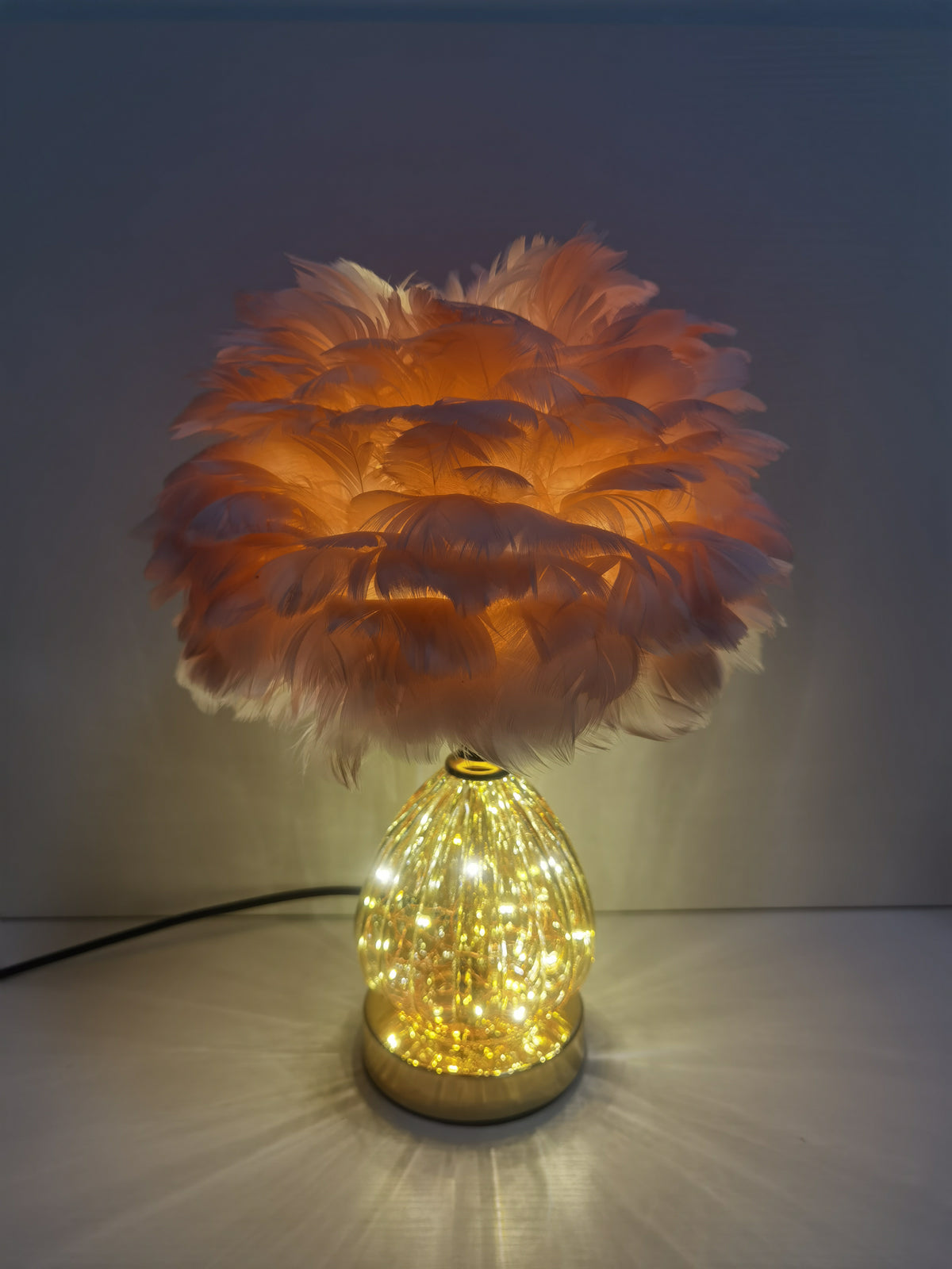 Bordlampe i glas med lyserøde fjer